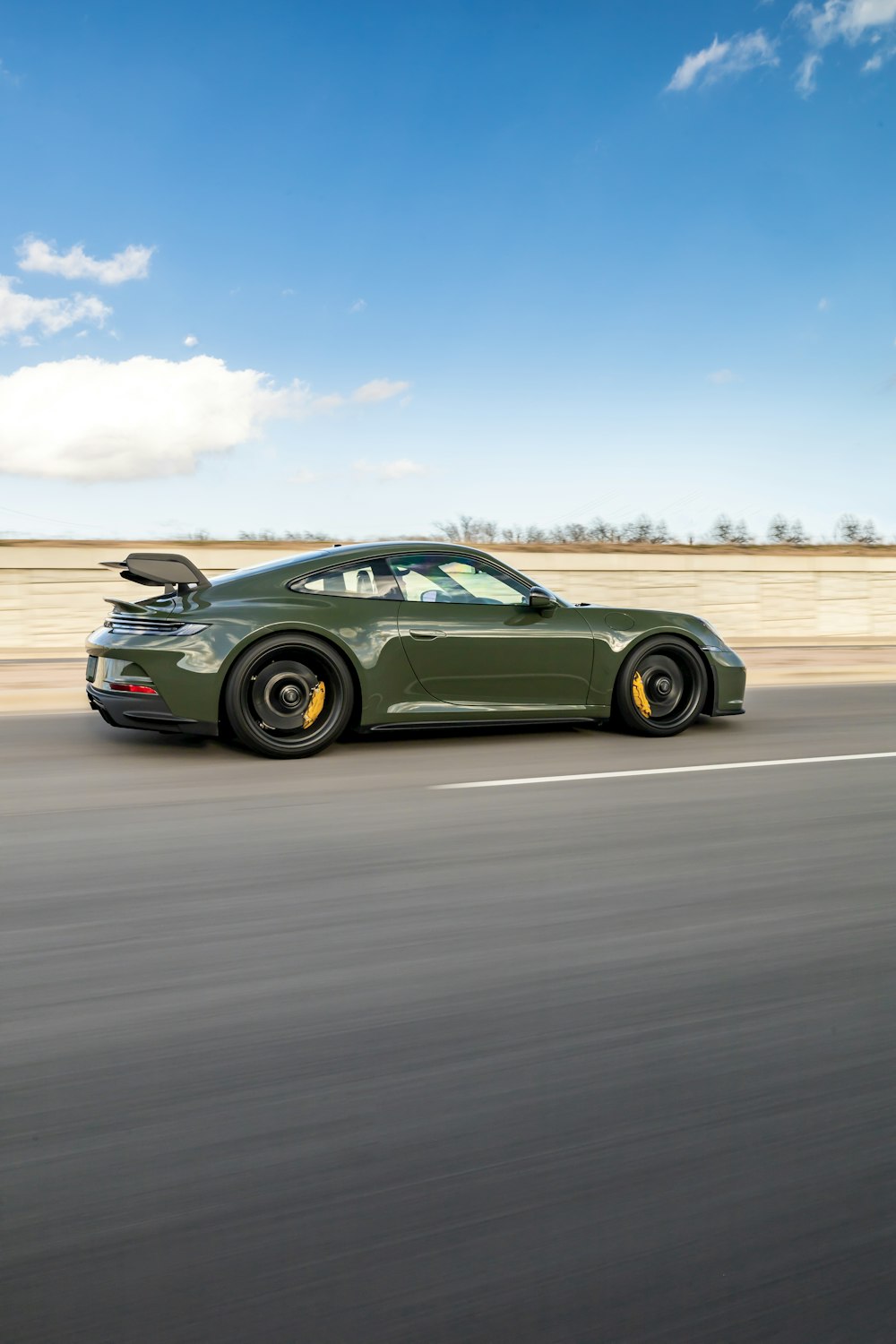 a green sports car driving down a highway
