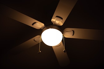 a ceiling fan with a light on it in a dark room