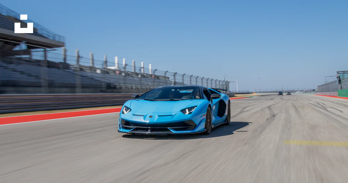 Blue Racing Pic A blue sports car driving down a race track photo – Free Blue Image on ...