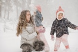 A joyful scene of the family enjoying a skiing trip together in fresh snow.