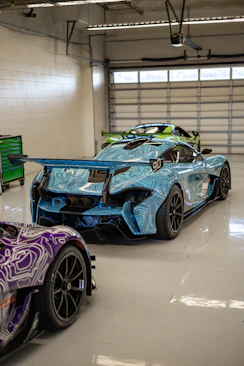 two race cars parked in a garage next to each other