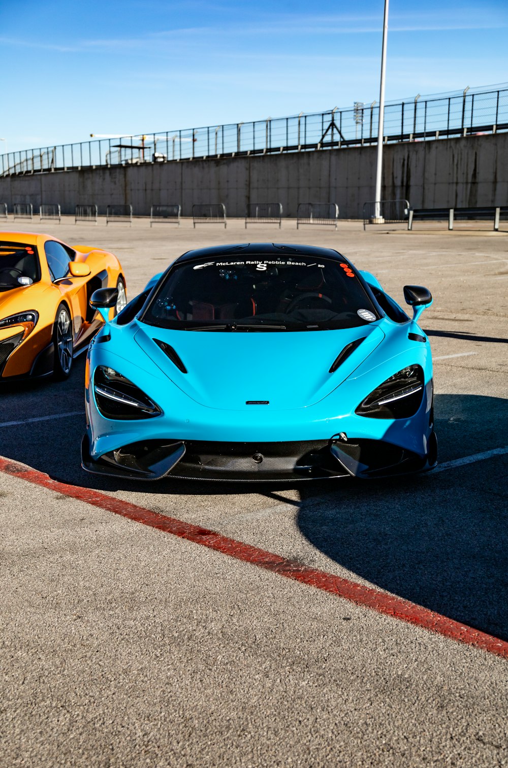 two blue and orange sports cars parked next to each other