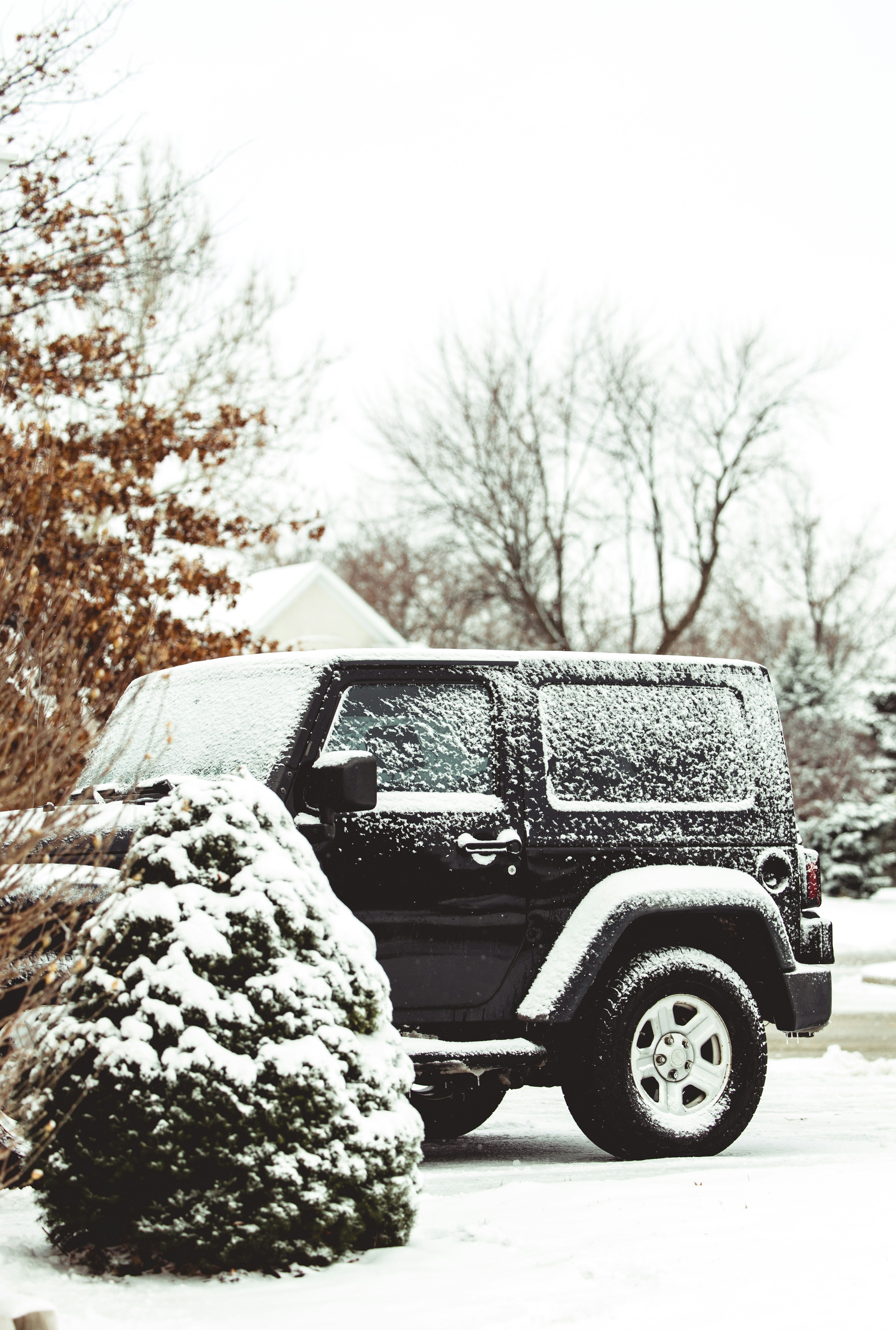 Une jeep noire garée dans une allée couverte de neige