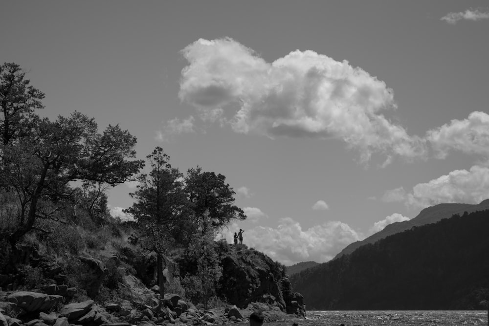 a black and white photo of a person standing on a rock