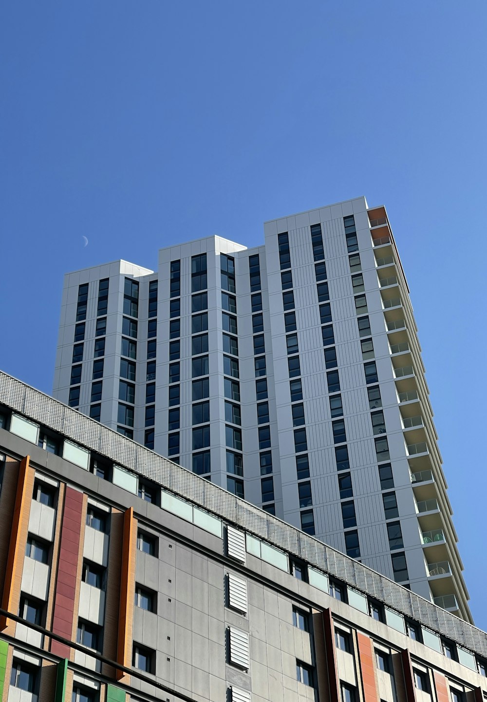 a tall building with multicolored windows against a blue sky