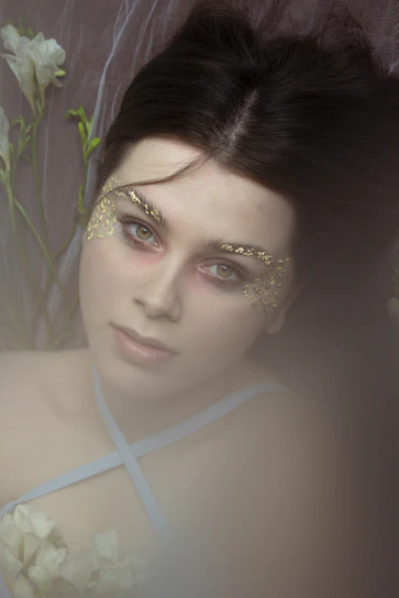 Portrait of Simonne Oliveira in a serene setting with golden star accents and sacred geometry in the background.
