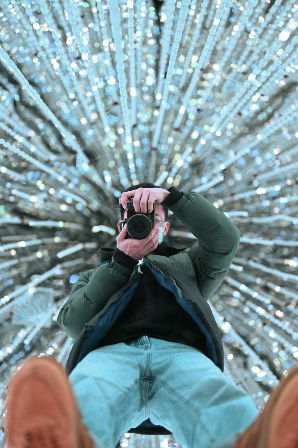 a man taking a picture of a large display of lights