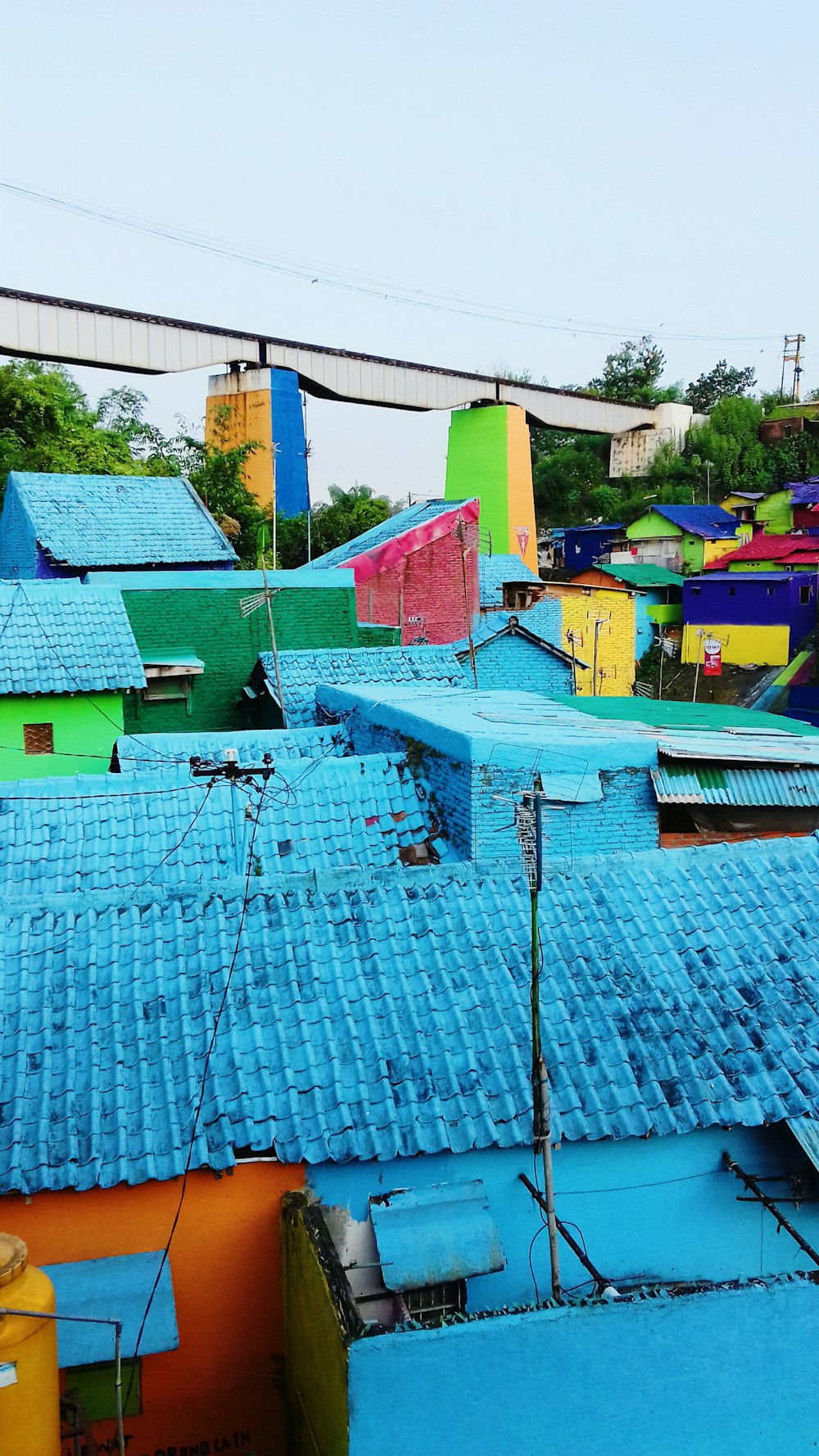 a group of colorful buildings with a bridge in the background