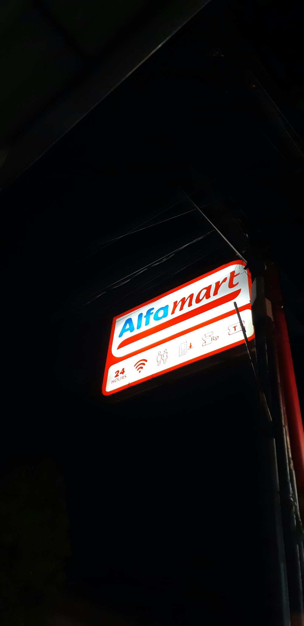 a red and white sign hanging from the side of a building