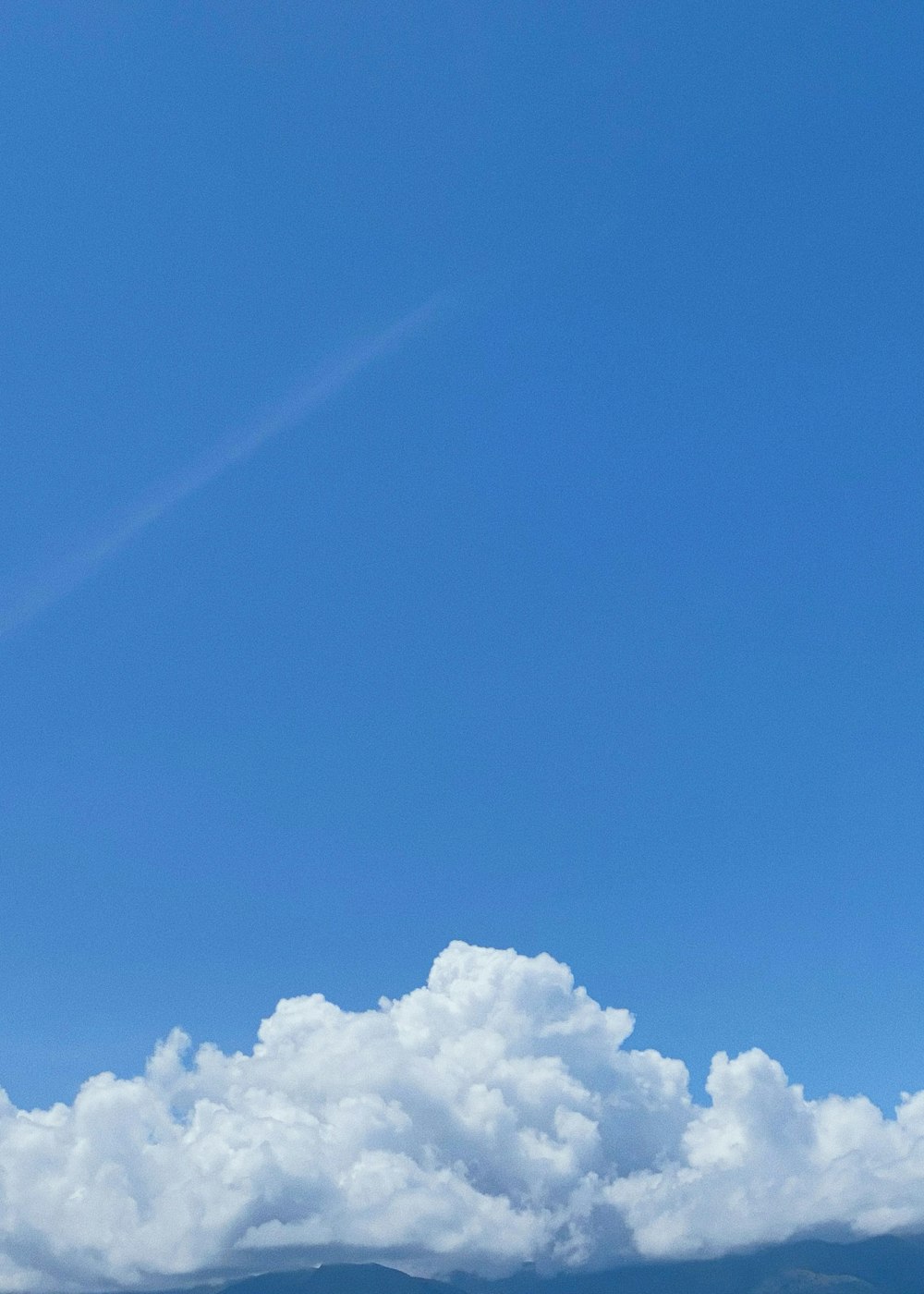 a plane flying high in the sky with clouds