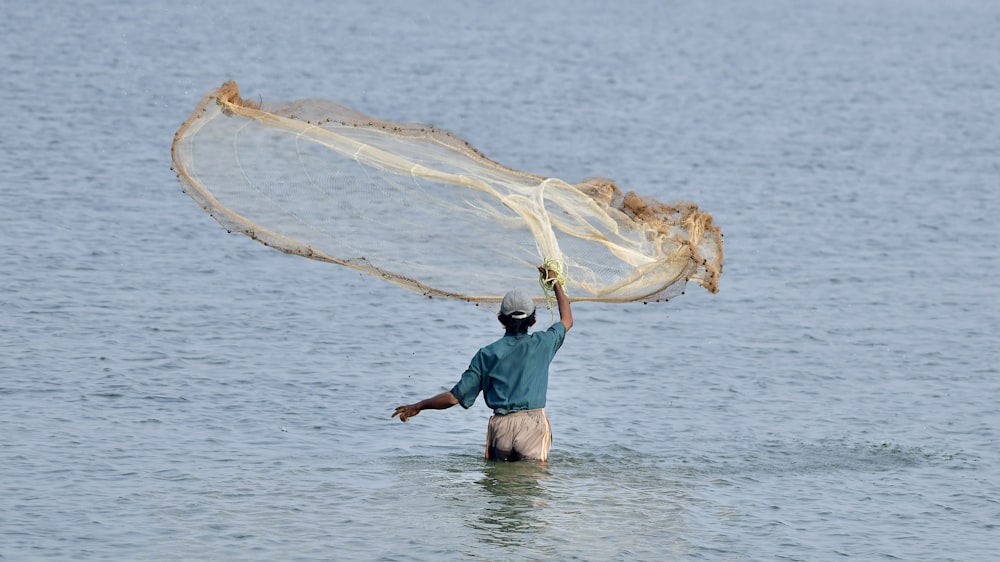 a man wading in the water with a fishing net