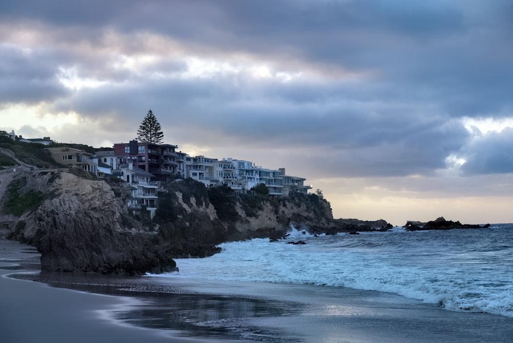 a view of a beach with houses on a cliff