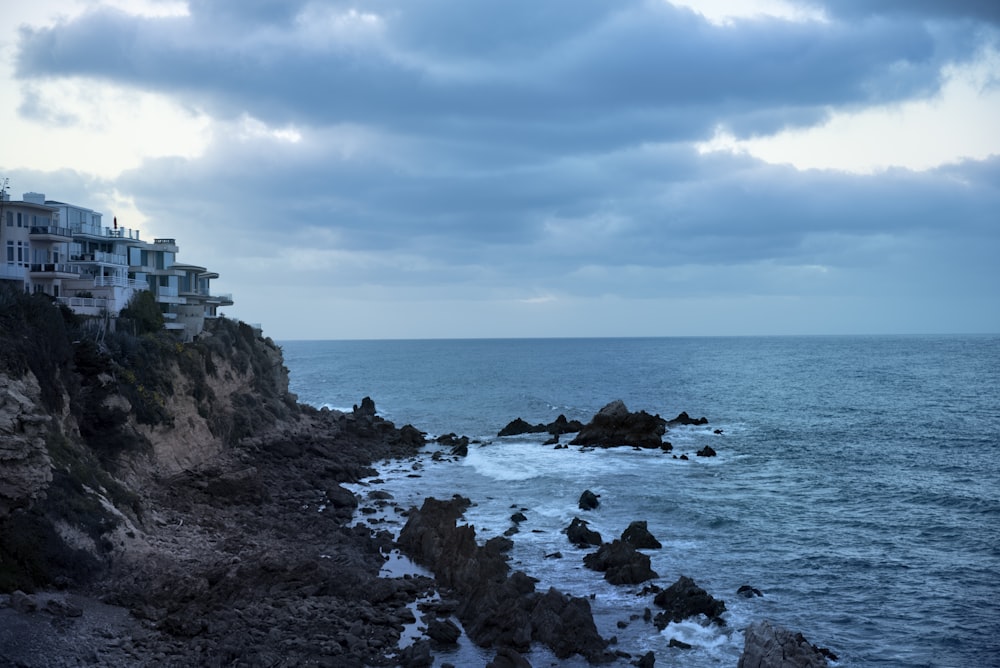 a view of the ocean with houses on the cliff