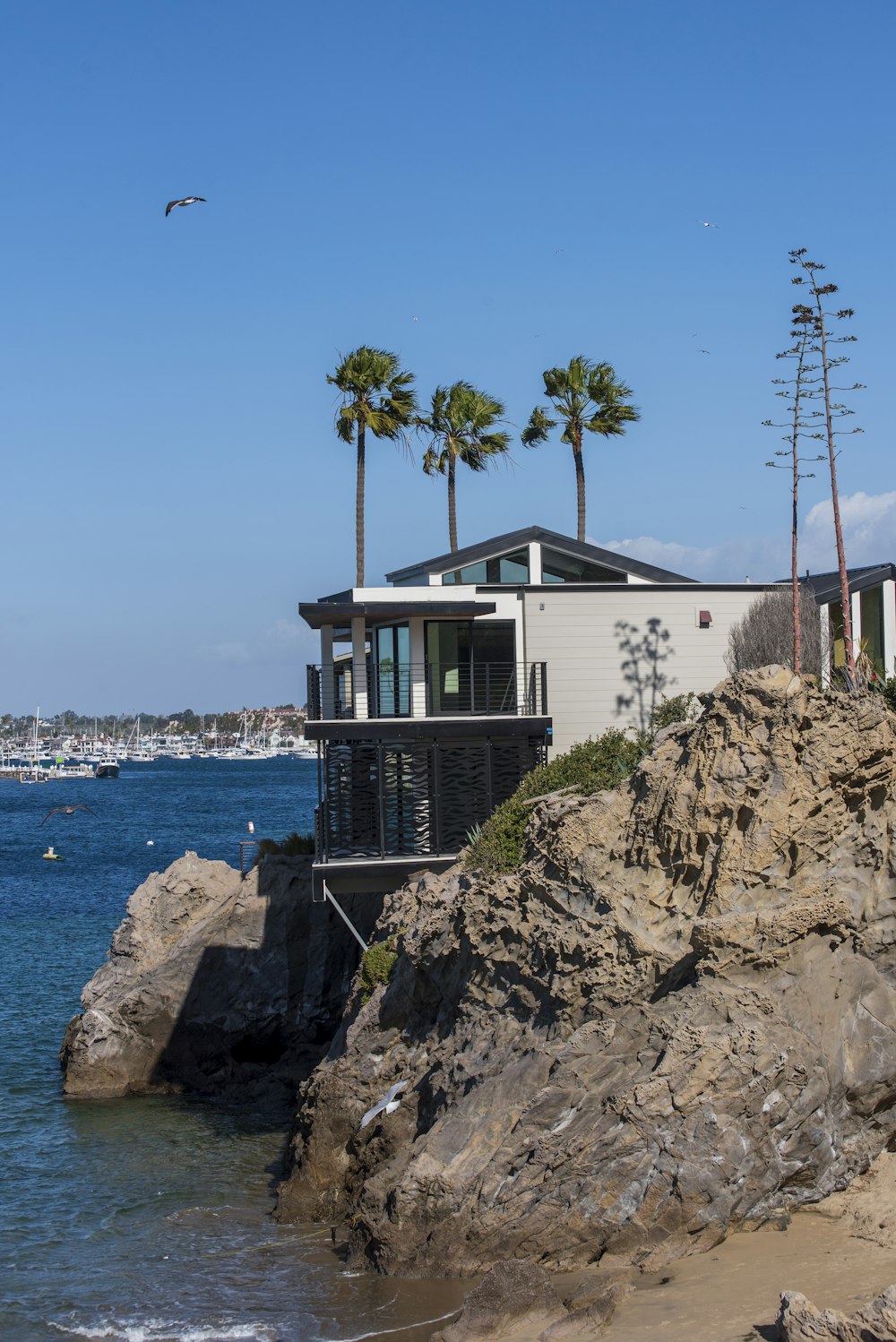 a house sitting on top of a cliff next to the ocean