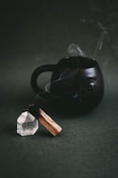 a black teapot with smoke coming out of it