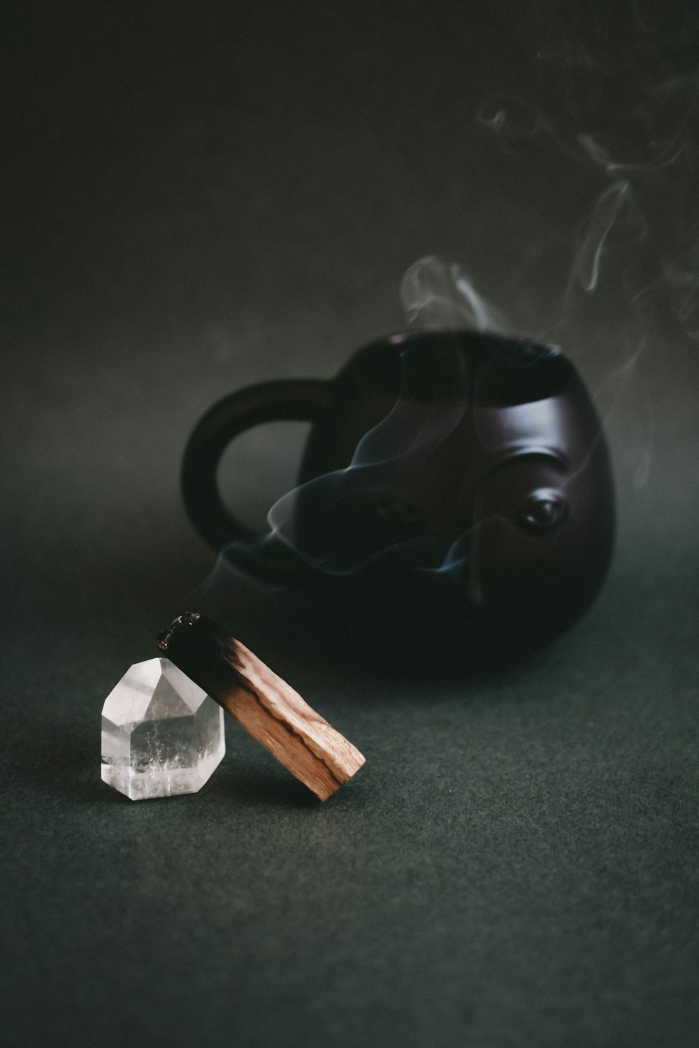 a black teapot with smoke coming out of it