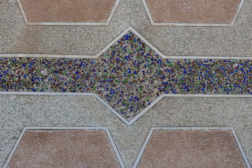 a close up of a tiled wall with blue and green glass