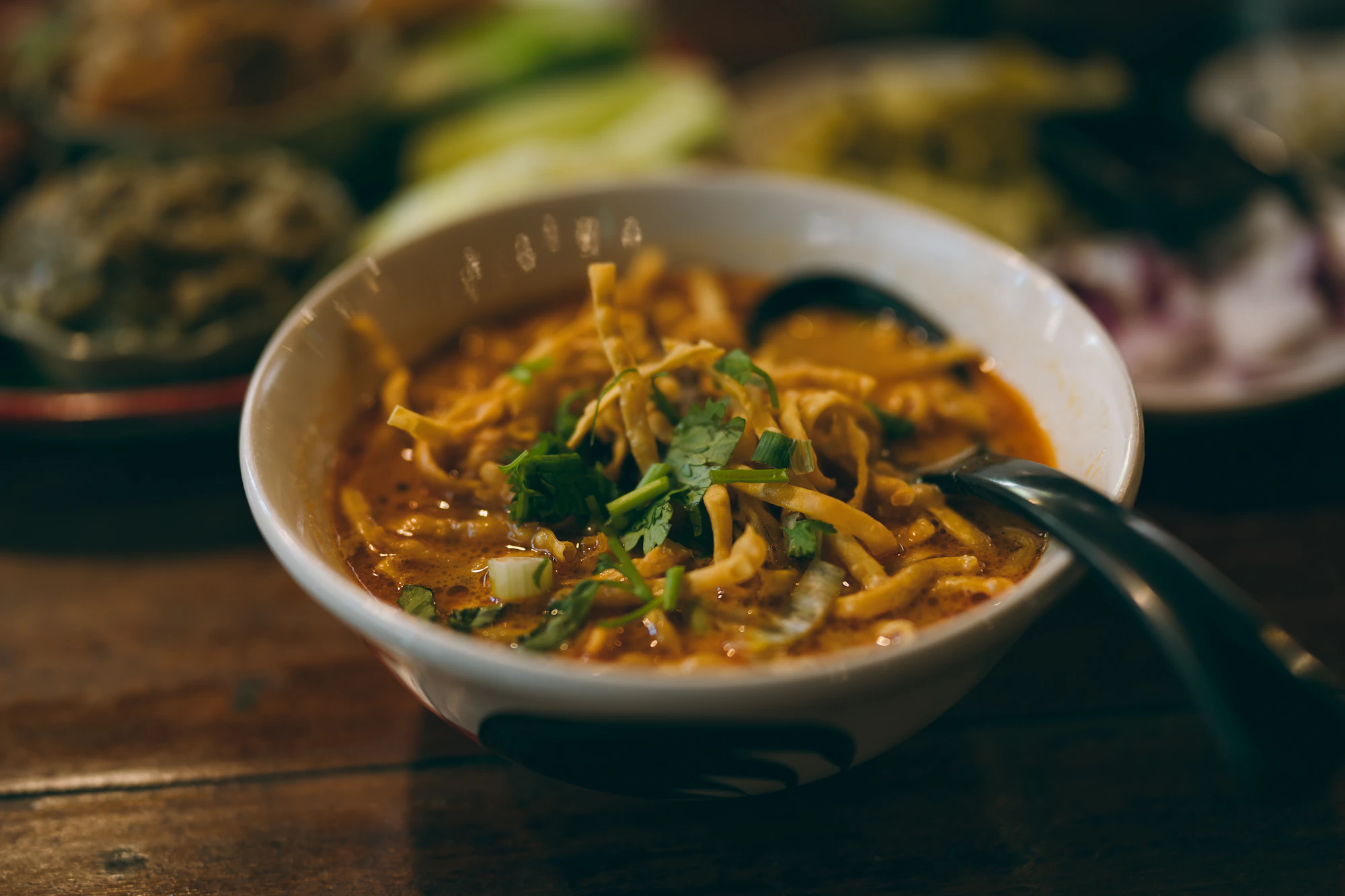 Khao Soi with crispy noodles, coconut curry broth and accompaniments