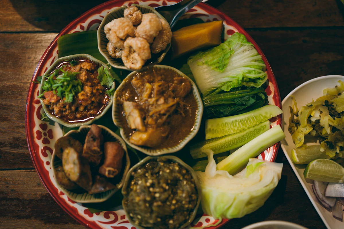 Thailändsk tallrik med olika smårätter på bananblad