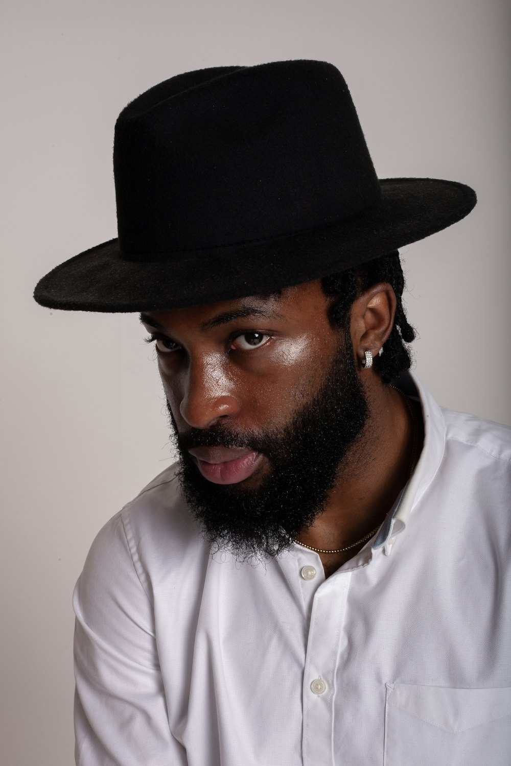 a man with a beard wearing a black hat