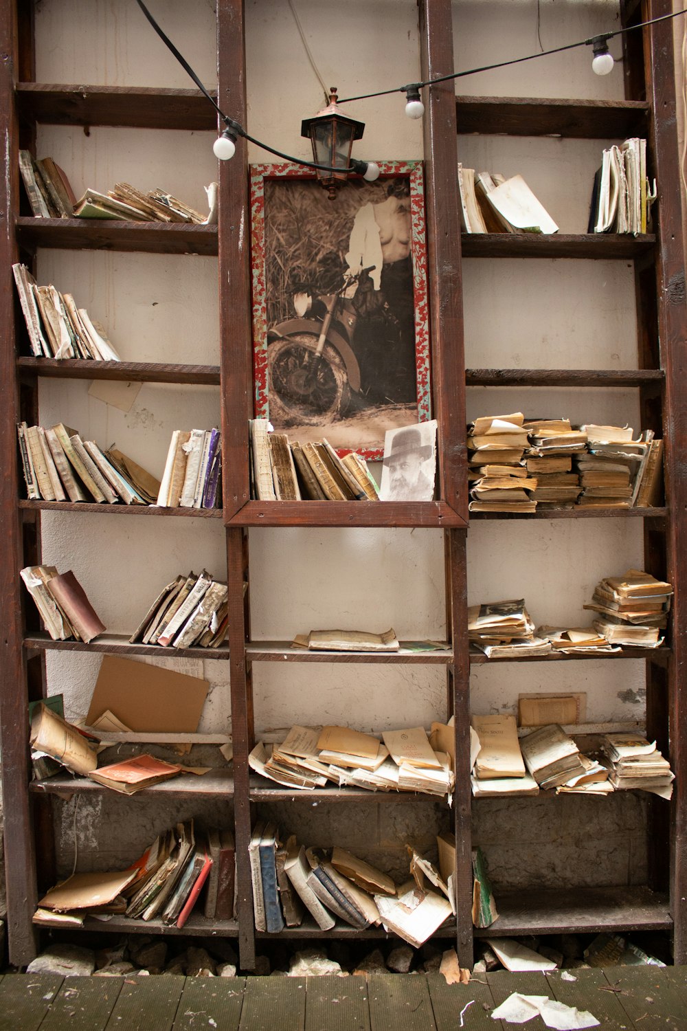 a bookshelf filled with lots of books on top of a wooden floor