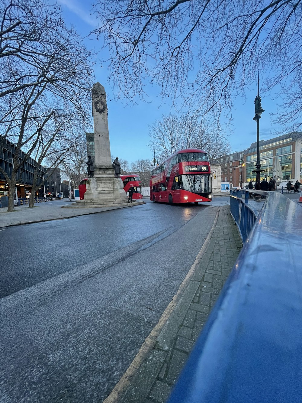 a red double decker bus driving down a street