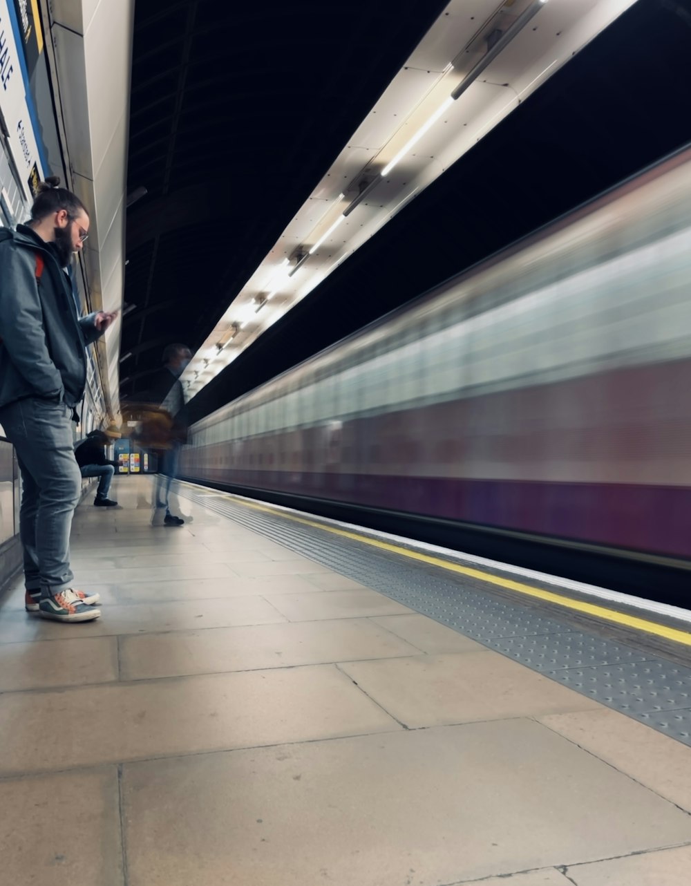 a man standing on a platform next to a train