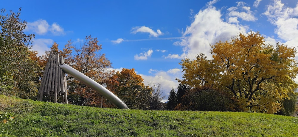 a large pipe sitting on top of a lush green hillside