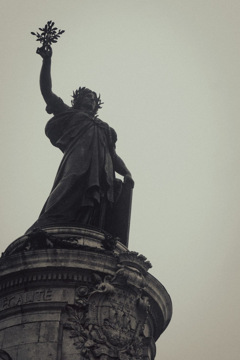 a statue of a man holding a flower on top of a building