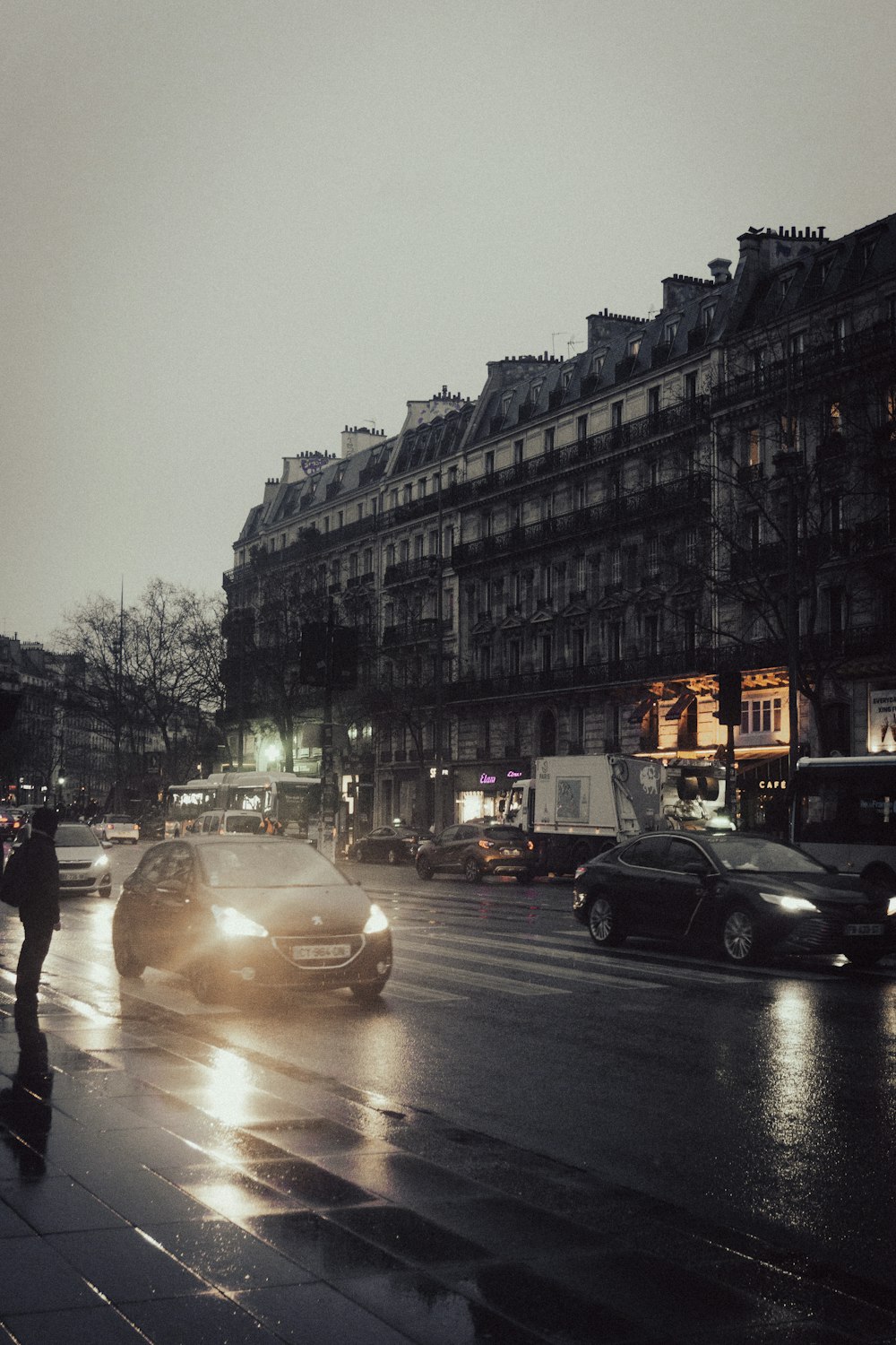 a city street with cars and people walking on the sidewalk