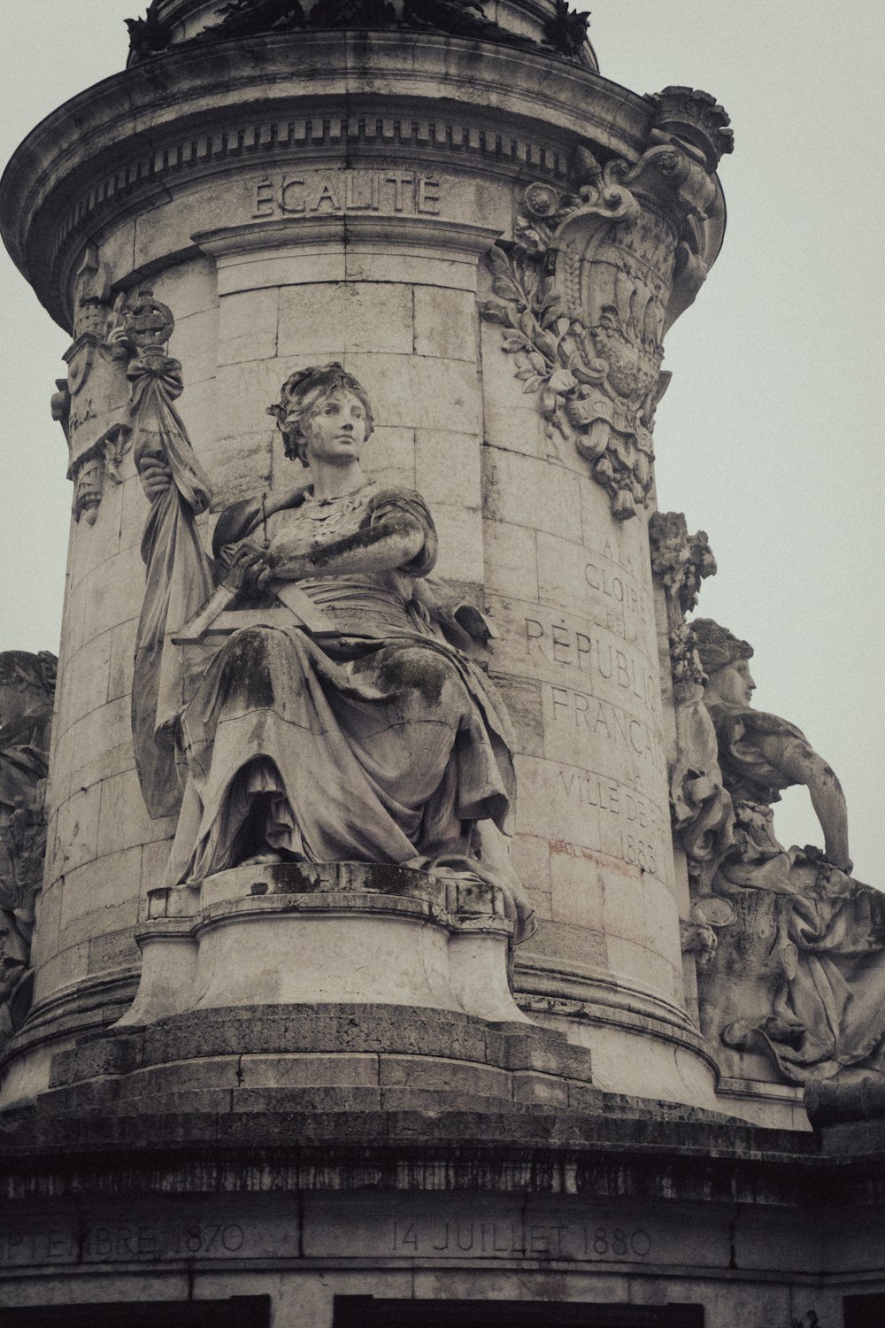 a statue of a woman holding a child on top of a building