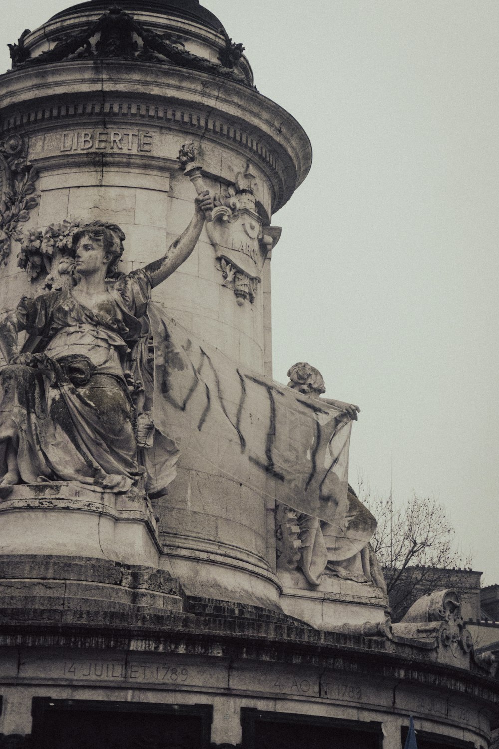 a statue on top of a building with a clock tower in the background