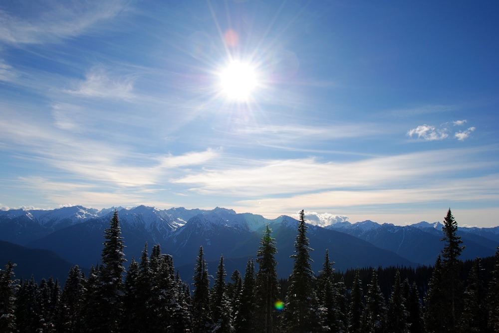 the sun shines brightly over a mountain range