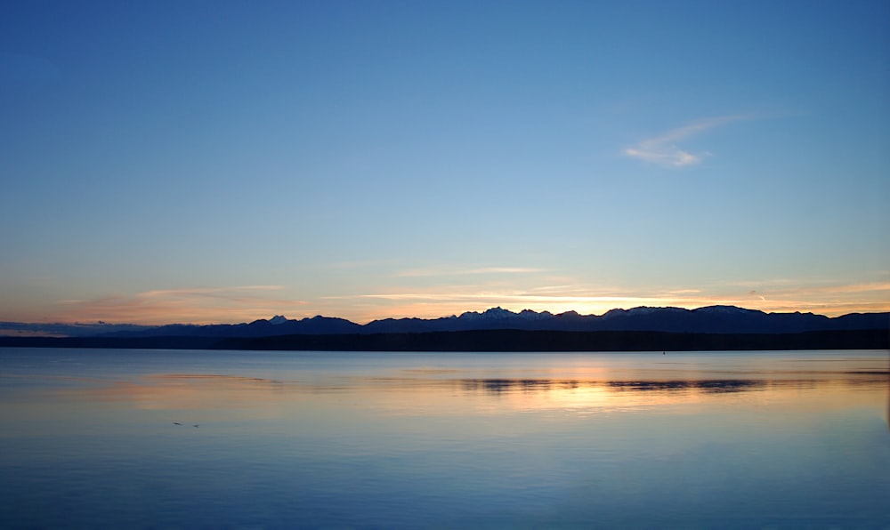 a large body of water with mountains in the background