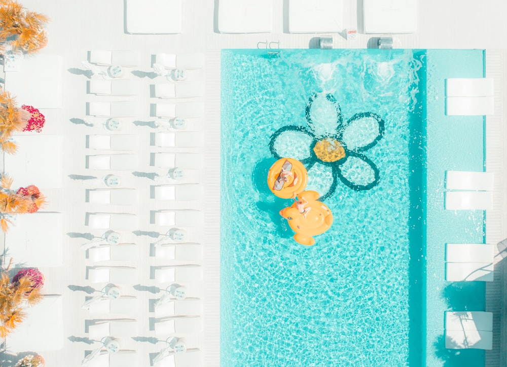 an overhead view of a pool with chairs and umbrellas