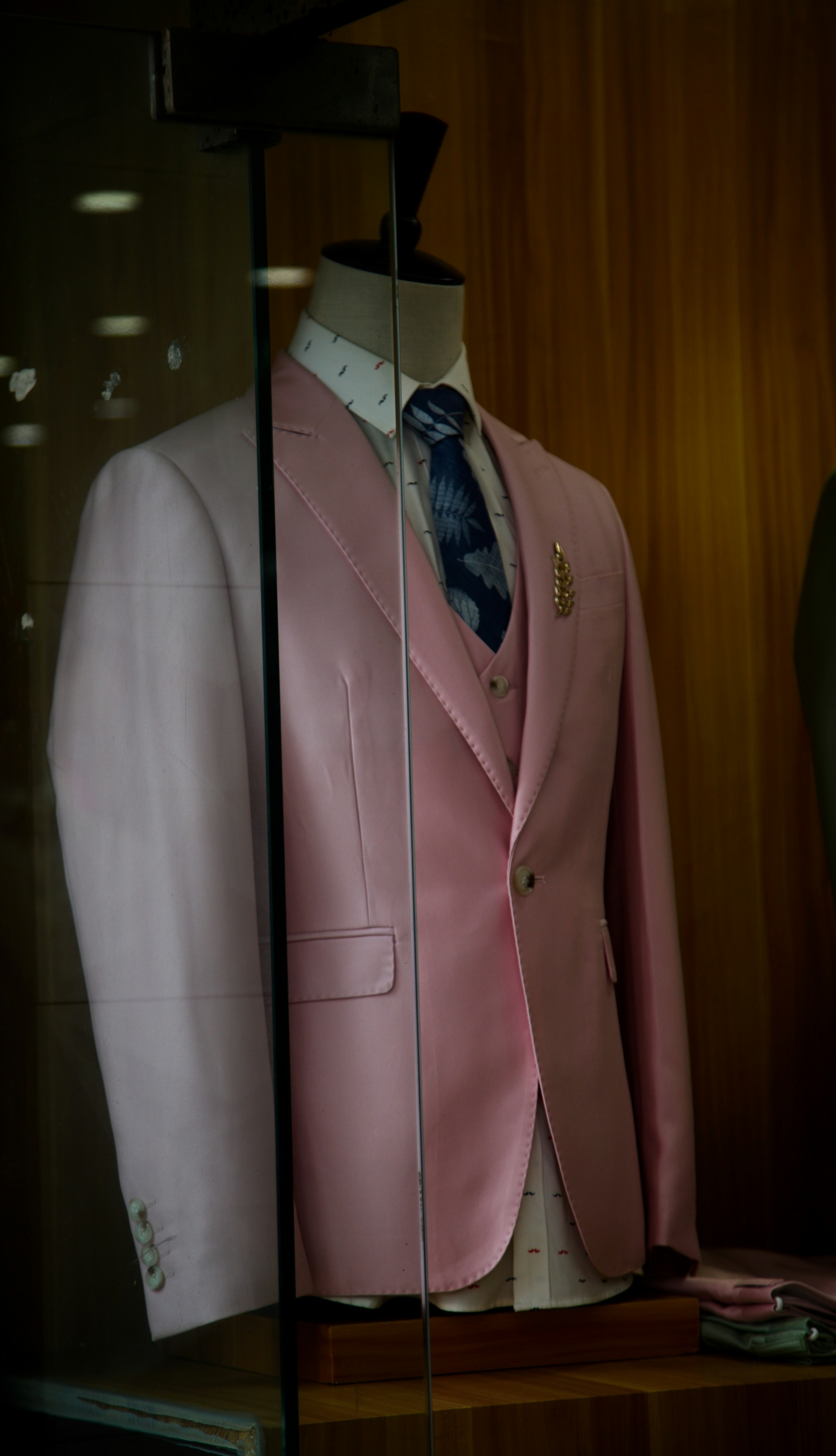 a pink suit and tie on display in a glass case
