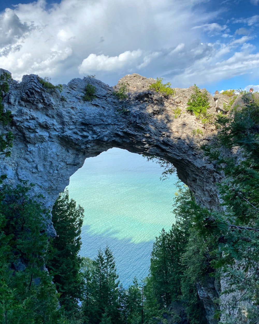 a large rock arch over looking a body of water