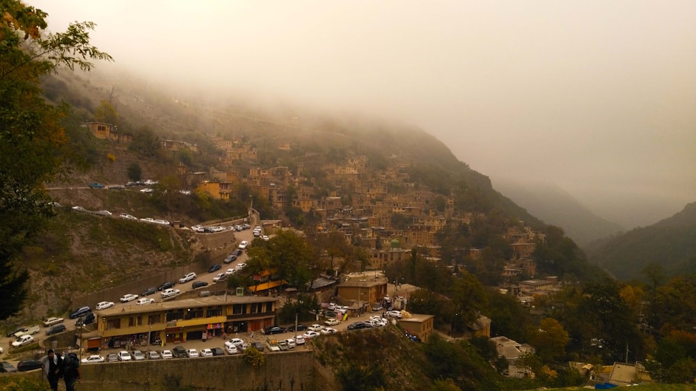 a foggy view of a city with cars parked on the side of a hill