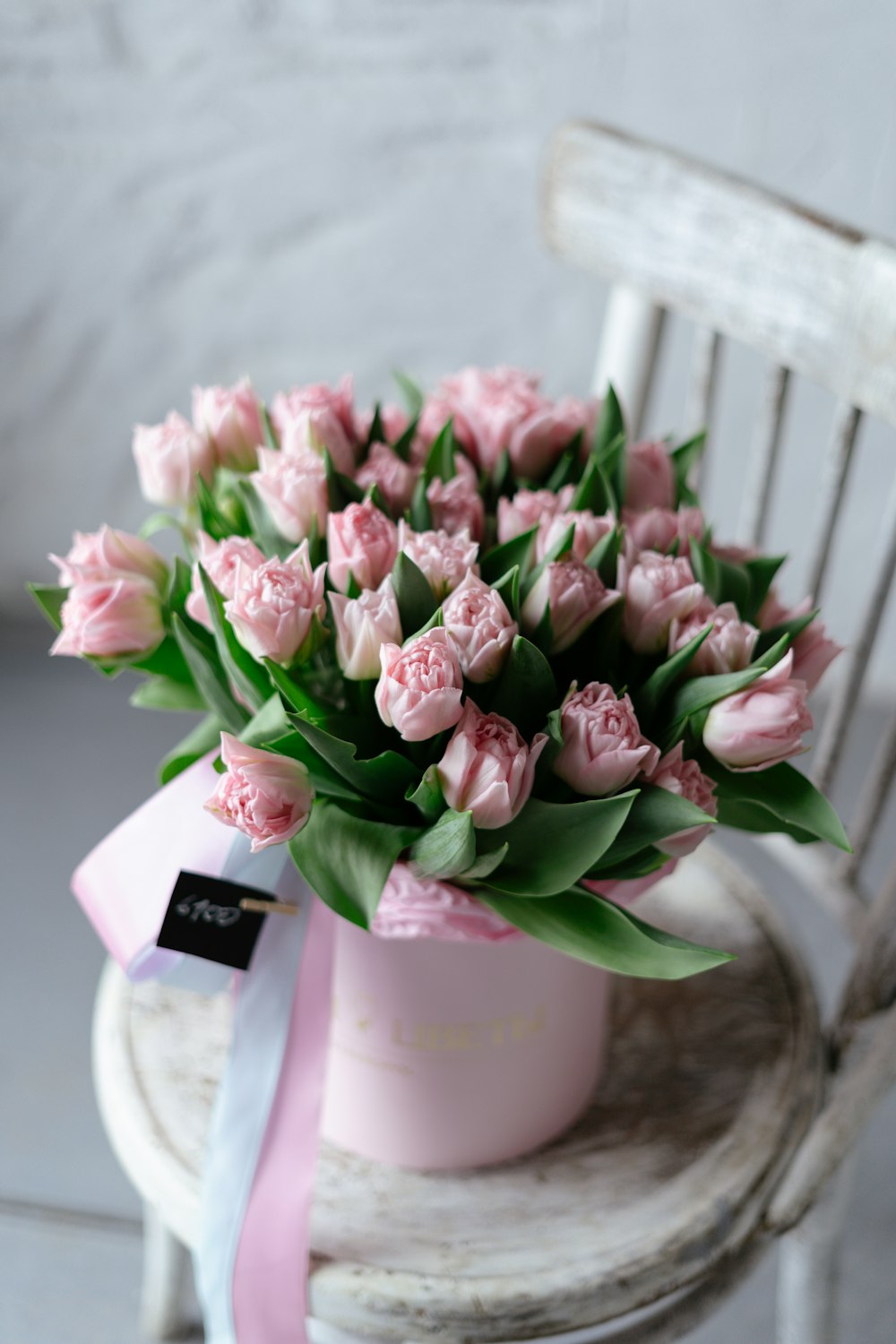 a bouquet of pink flowers sitting on top of a chair
