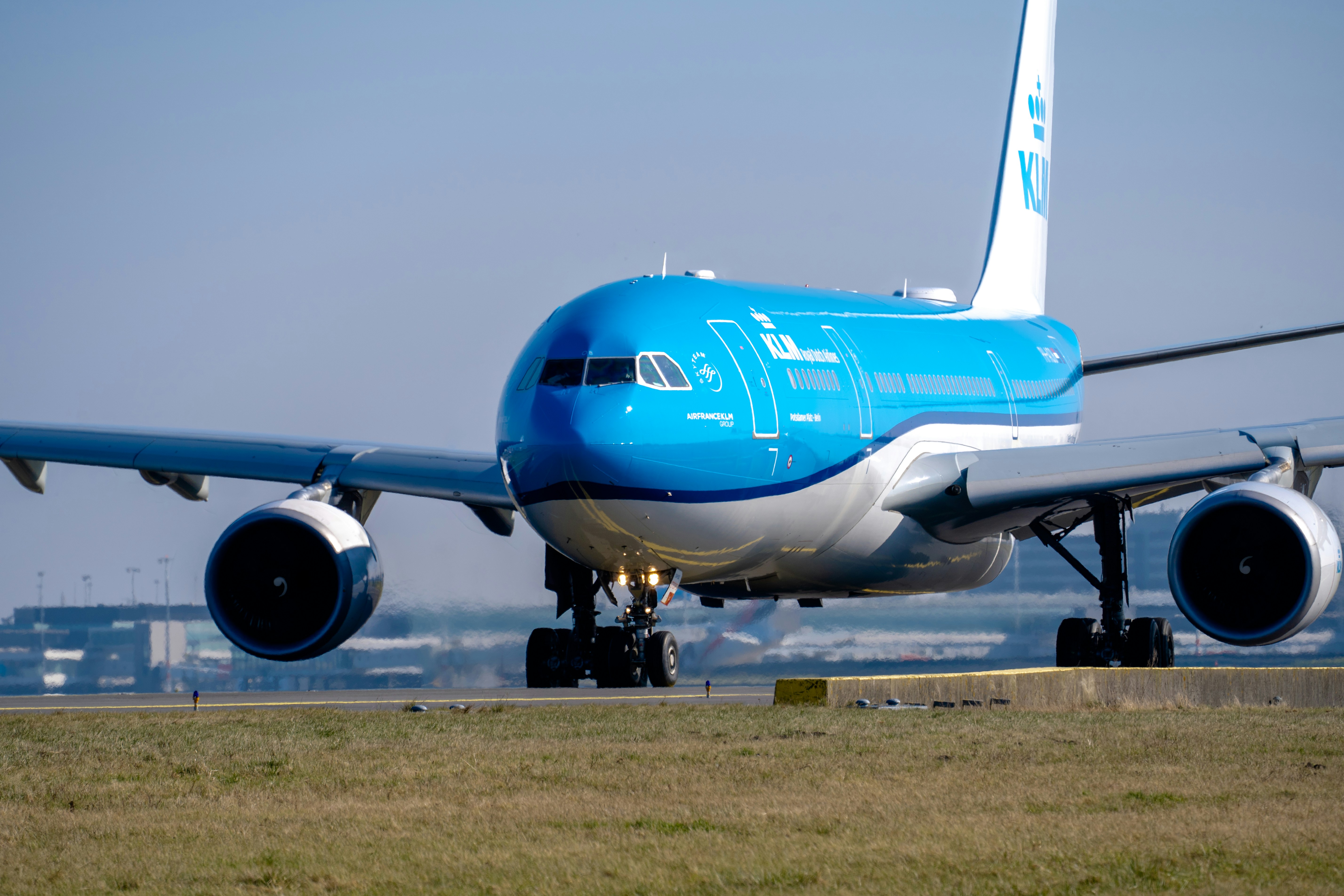 a large jetliner sitting on top of an airport runway, An Airbus A330-203 (reg. PH-AOB), serving KLM flight 681 from Amsterdam to Vancouver, taxiing to the runway at Schiphol Airport.