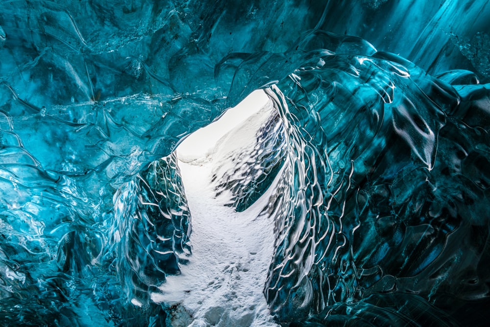 une très grande grotte de glace avec un peu de neige au sol