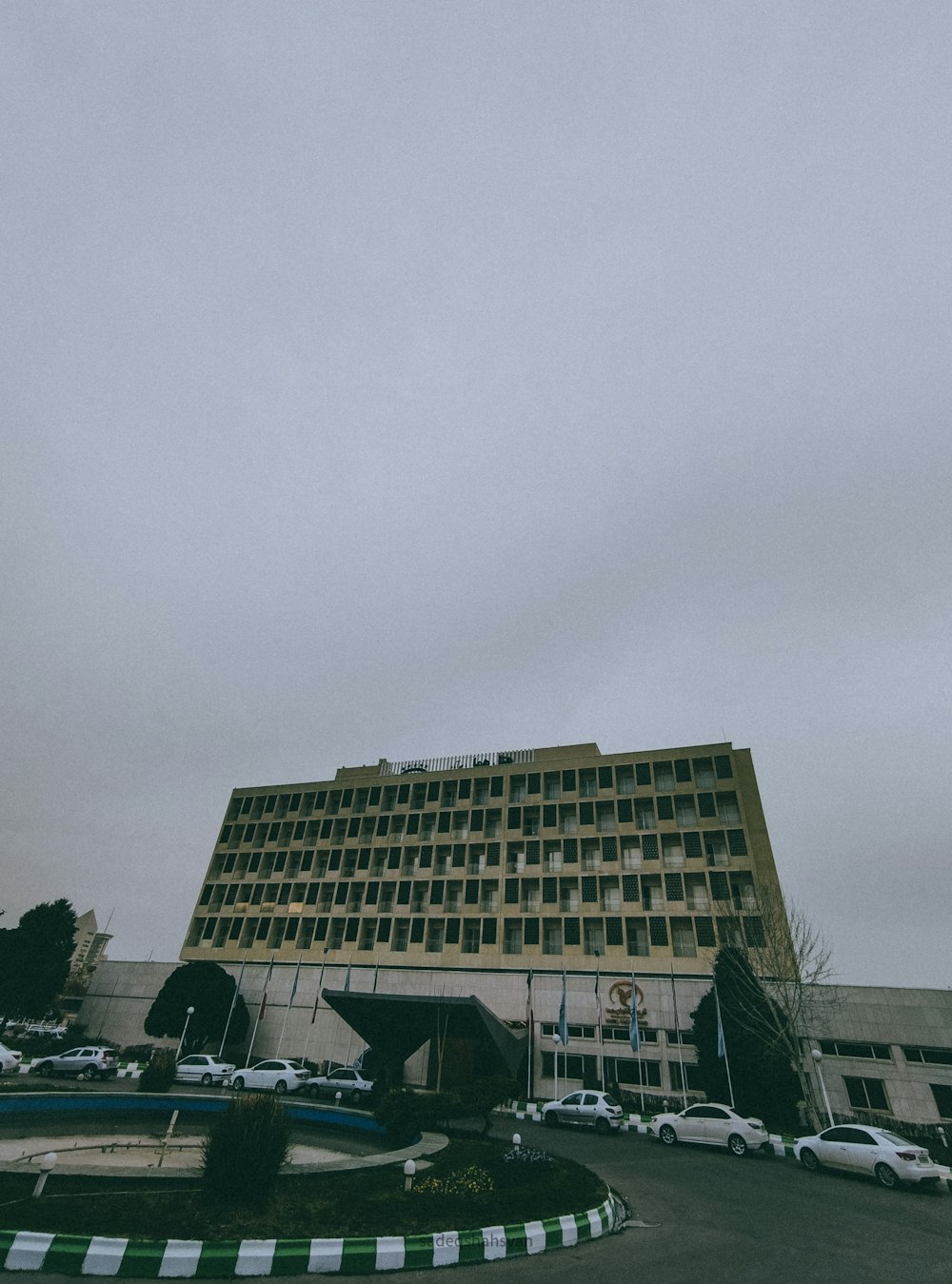 a very tall building with cars parked in front of it