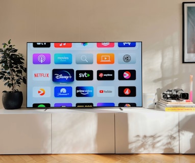 a flat screen tv sitting on top of a white cabinet