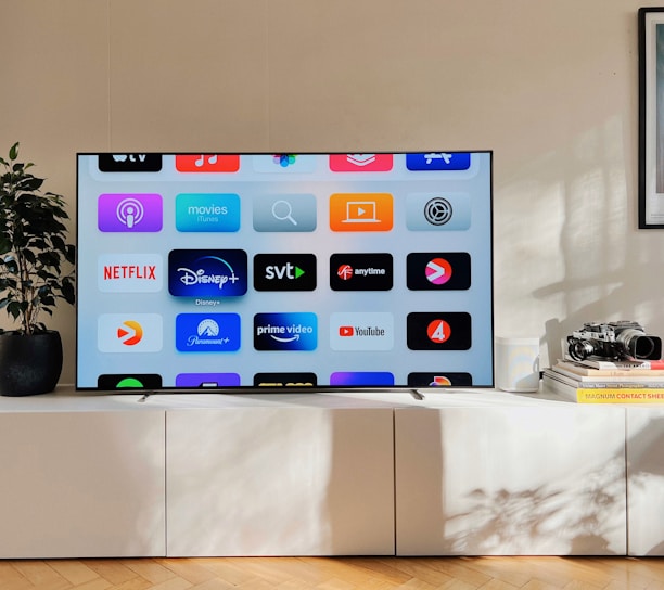 a flat screen tv sitting on top of a white cabinet