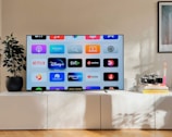 a flat screen tv sitting on top of a white cabinet