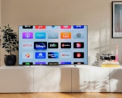 a flat screen tv sitting on top of a white cabinet