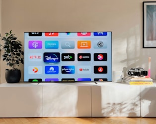 a flat screen tv sitting on top of a white cabinet