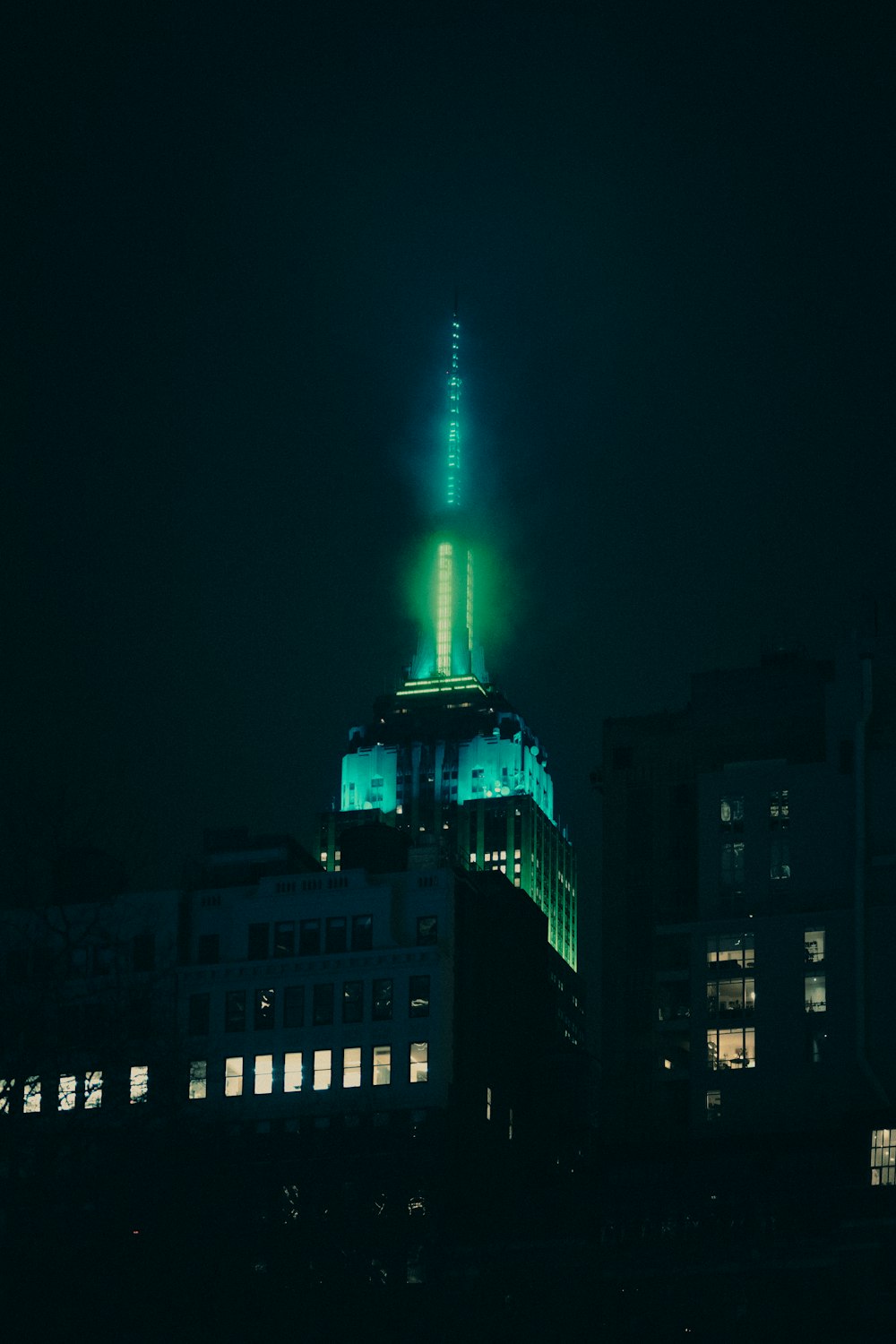 a very tall building with a green light on top of it