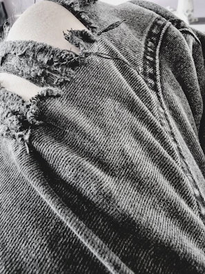 Close-up of a pair of slim-fit ripped jeans with detailed stitching.