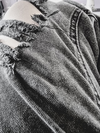 A close-up of unique details on a pair of boyfriend jeans.
